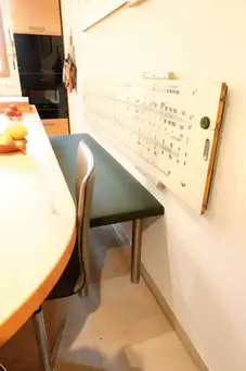 Vierfüßige gepolsterte Stahlbank mit Schulrechenschieber als Rückenlehne  