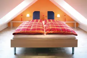 Massivholzbett im Dachgiebel Massivholzbett im Dachgiebel