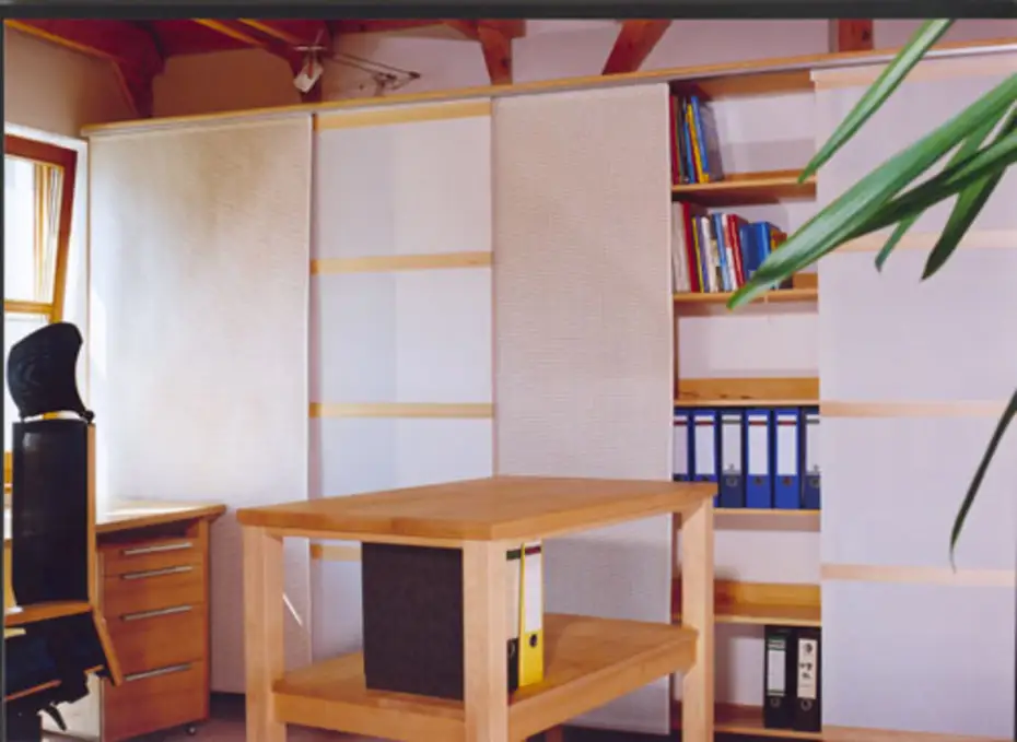 Ordner- und Bücherregal hinter Paneelwagen