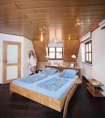 Schlafzimmer mit freistehendem Bett in Ahorn