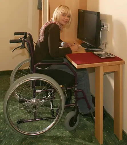 Massivholzschreibtisch für Rollstuhlfahrer im barrierefreien Hotelzimmer