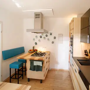 Kochinsel mit Hockern und Lehne an der Wand Kochinsel mit Hockern und Lehne an der Wand