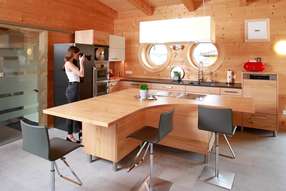 Massivholzküche mit Kochinsel in Flügelform  