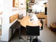 Vierbeinige Bank mit wandmontierter Holzlehne