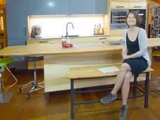 Geschwungene Bank mit Holzplatte und Vierfuß-Stahlgestell 