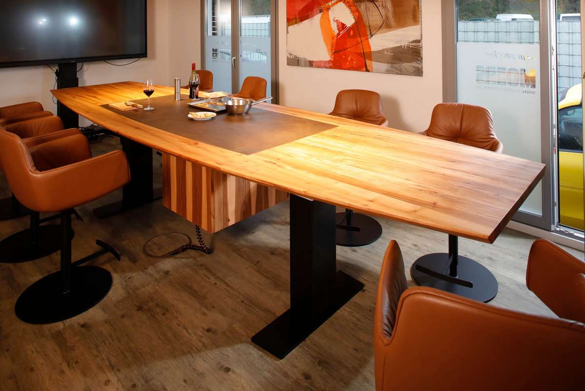 Der höhenverstellbare Konferenztisch mit unsichtbarem Kochfeld in Rüster Der höhenverstellbare Konferenztisch mit unsichtbarem Kochfeld in Rüster